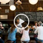 A group of people sitting at a restaurant bar.